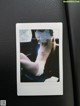 A polaroid photo of a naked woman sitting in a car.